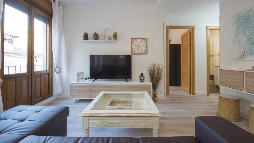 a living room with a tv and a coffee table at Apartamento Pasaje del Barco by Toledo AP in Toledo