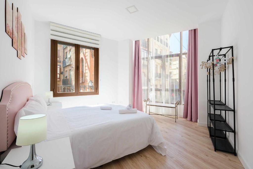 um quarto branco com uma cama grande e uma janela em El Mirador de la Catedral by Toledo AP em Toledo