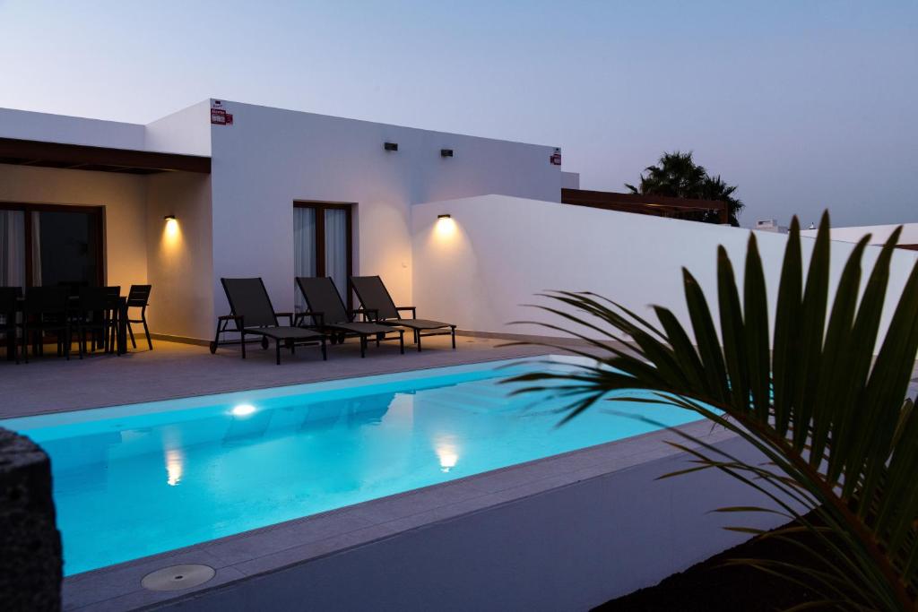 a villa with a swimming pool at night at Villas Altos de Lanzarote in Playa Blanca