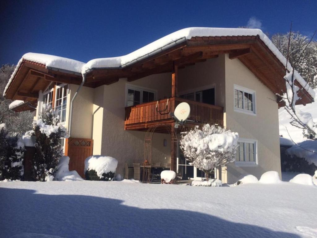 Una casa con nieve en el techo. en Watzmann-Appartement, en Ramsau