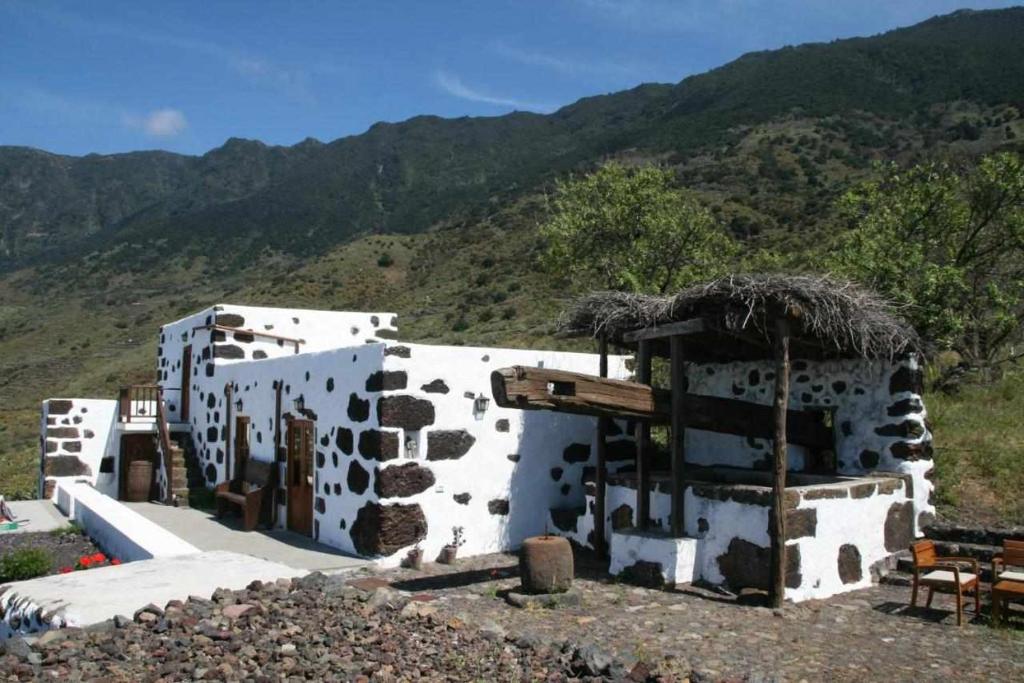 een gebouw met een berg op de achtergrond bij Casas Rurales Puerto Escondido in Tigaday