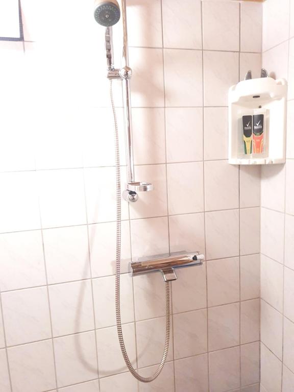 a shower with a shower head in a bathroom at Mukava talo maaseudulla lähellä keskustaa in Pori