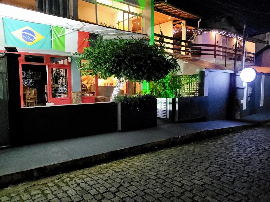 um edifício com uma bandeira ao lado à noite em Pousada Danitato e lavanderia em Bom Jardim