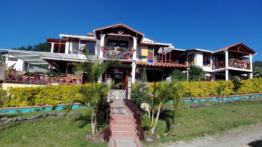une maison sur une colline avec des palmiers devant elle dans l'établissement Casa Rural La Boira, à Jardín