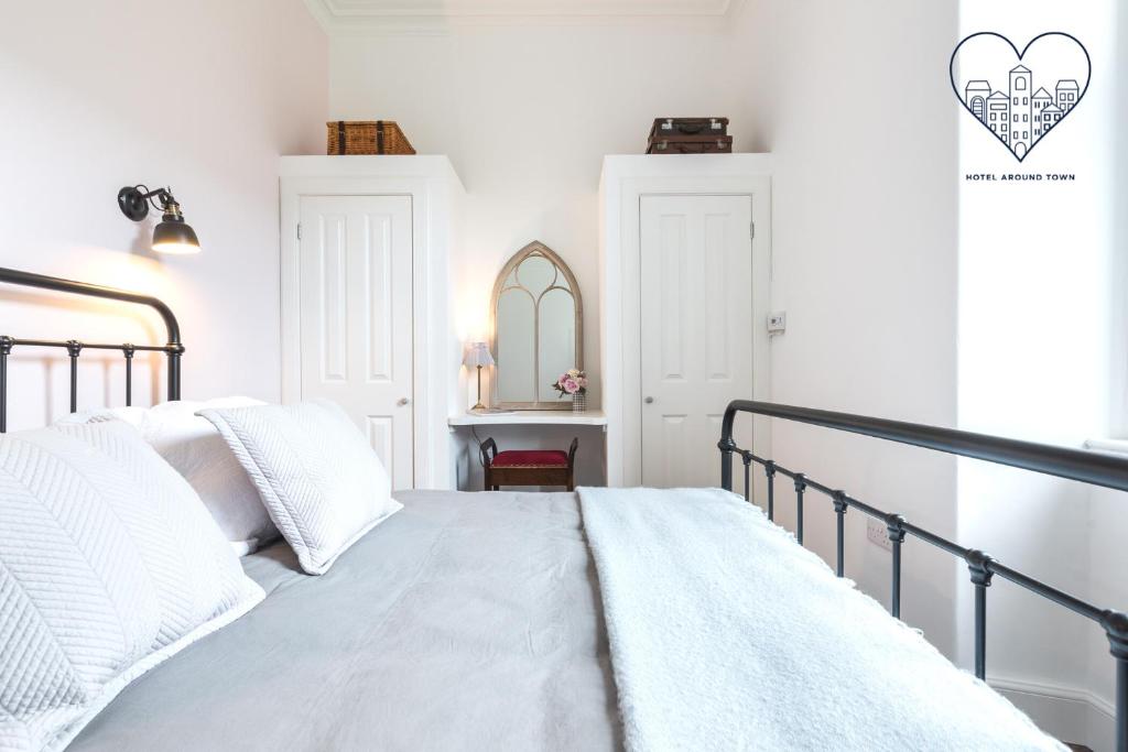 una camera bianca con letto e specchio di Newly renovated stunning apartment in Stockbridge a Edimburgo