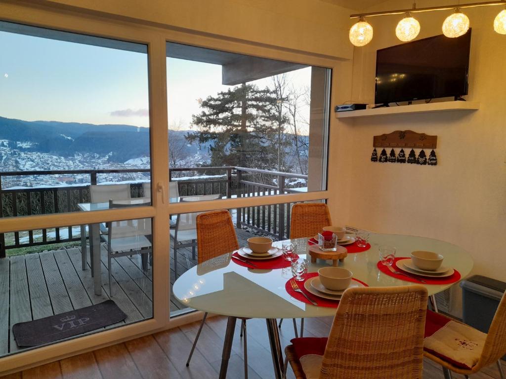 une salle à manger avec une table et des chaises et un balcon dans l'établissement Le Lougo, à Gérardmer