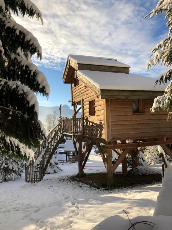une cabane en rondins dans la neige avec un escalier en bois dans l'établissement La Cabane à l'Orée des Bornes, à Évires