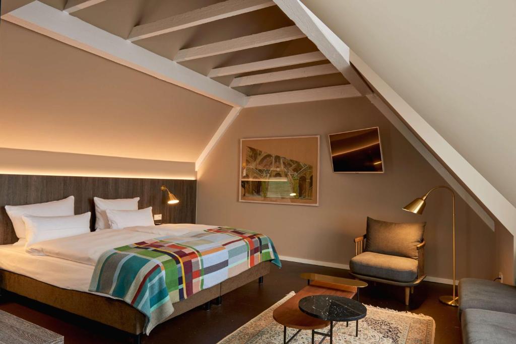 ein Hotelzimmer mit einem Bett und einem Stuhl in der Unterkunft Central Hotel Münster in Münster