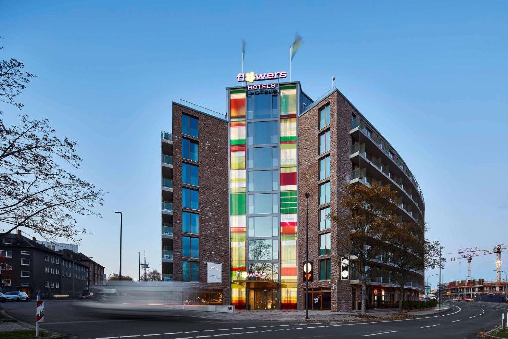wysoki budynek z kolorowymi oknami obok ulicy w obiekcie Flowers Hotel Essen w Essen