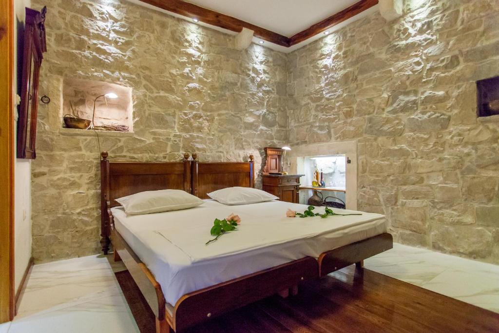 a bedroom with a bed in a stone wall at Studios Balic Lux in Split