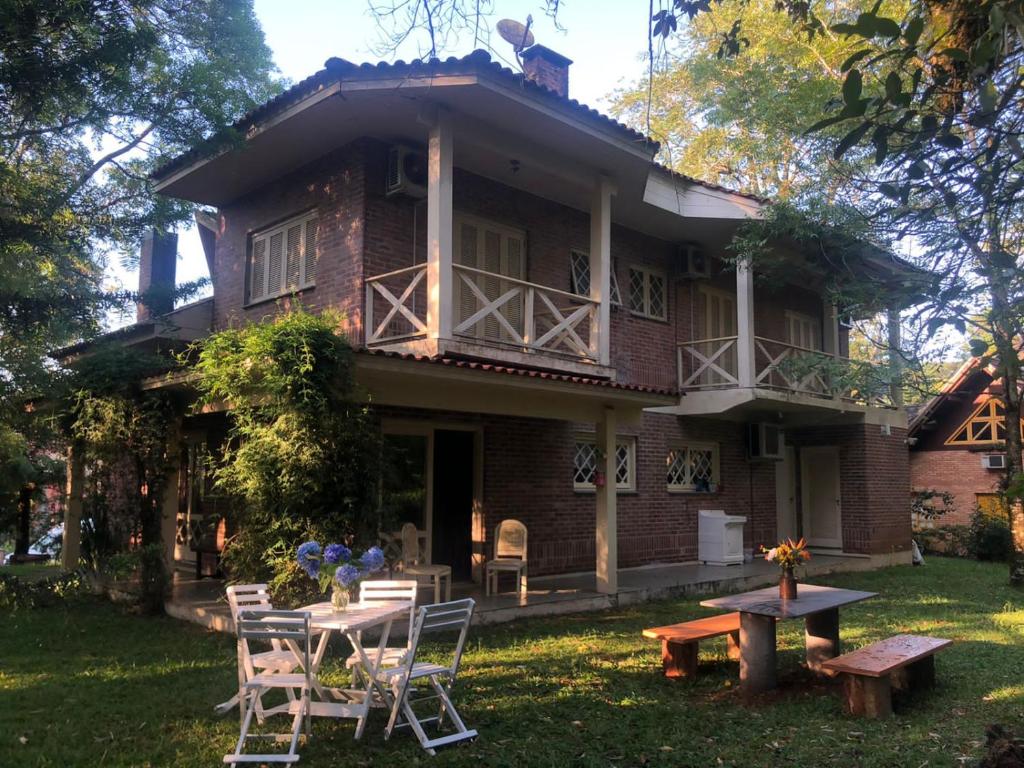 a house with a table and chairs in the yard at Casa do Bosque, espaçosa e confortável em condominio espetacular, 5 min centro! in Gramado