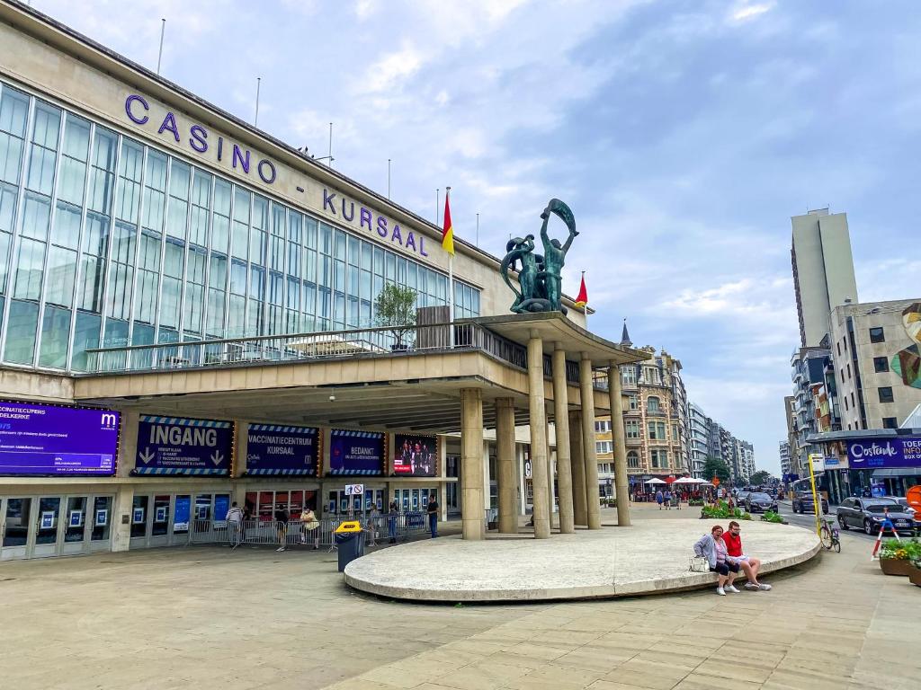 a building with people sitting in front of it at CASA MARE hartje Oostende met gratis parking in Ostend