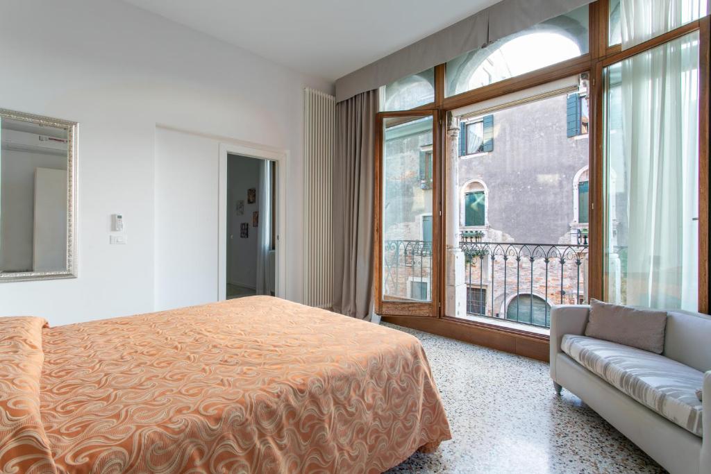 a bedroom with a bed and a large window at Canaletto Apartments in Venice