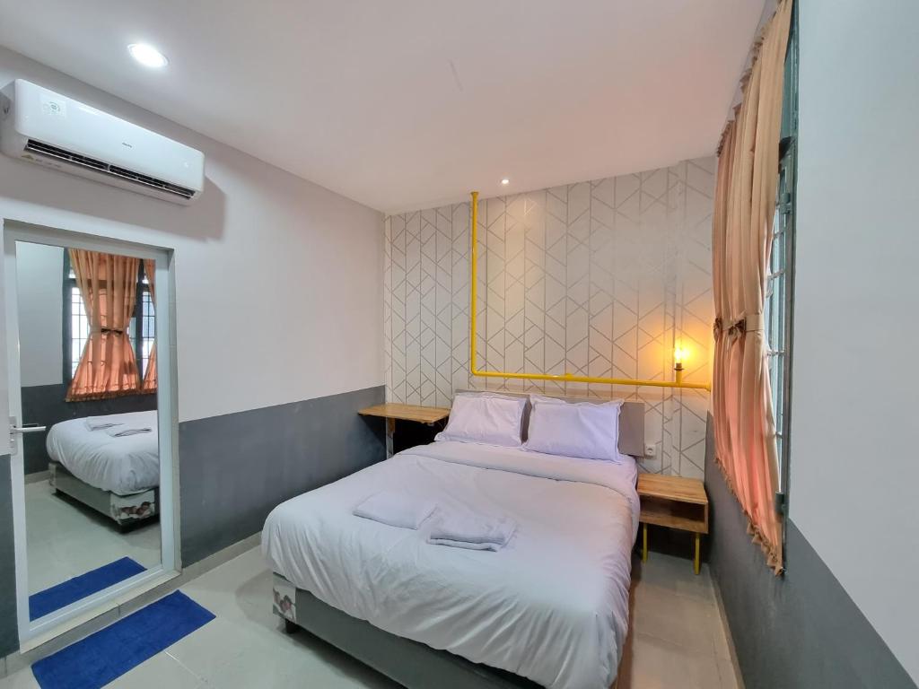 sypialnia z łóżkiem i lustrem w obiekcie Super OYO Capital O 90874 Millenium Inn 2 w mieście Medan