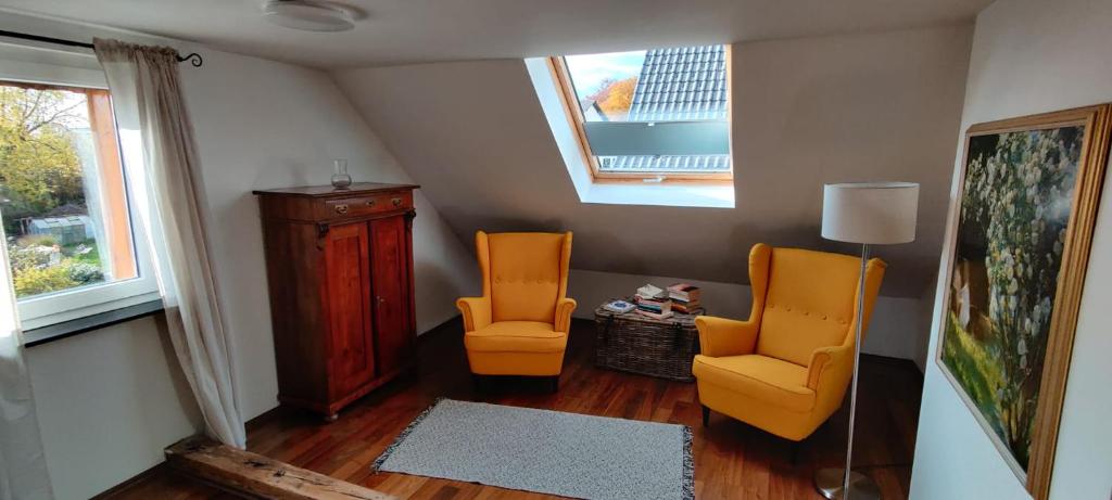 a living room with two orange chairs and a window at Tinyloft in Beerfelden