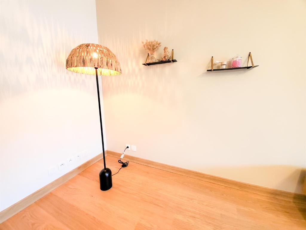 a lamp sitting on the floor next to a wall at Standing appartement avec vue sur la Mayenne in Laval