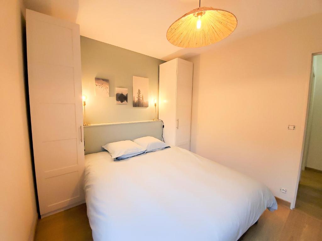 a bedroom with a bed with two pillows on it at Standing appartement avec vue sur la Mayenne in Laval