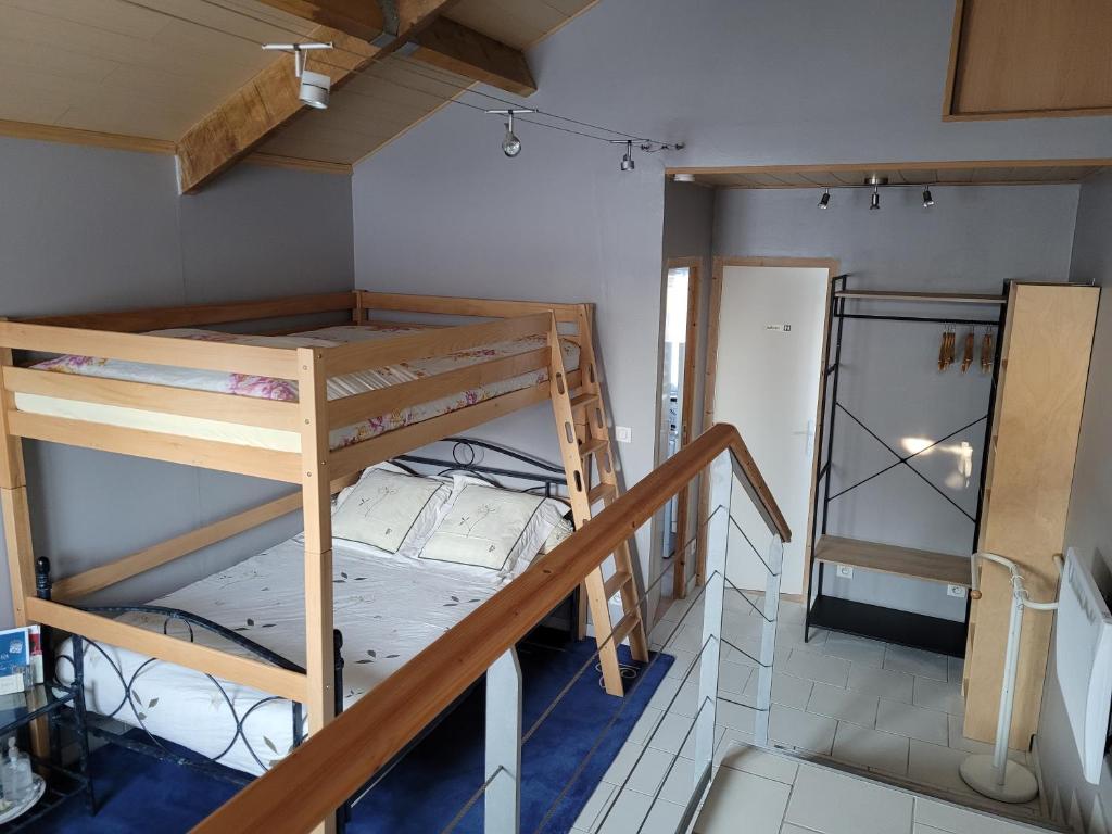 Zimmer mit 2 Etagenbetten und einer Treppe in der Unterkunft le studio in Chouilly