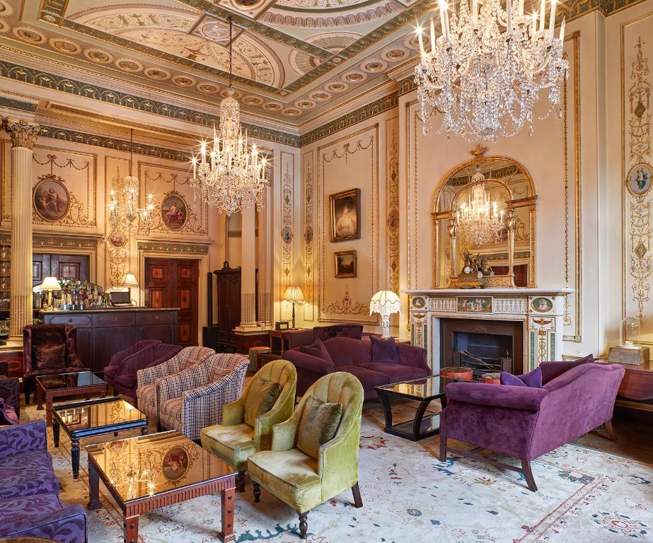 a living room with purple furniture and a chandelier at Home House - Private Member's Club in London