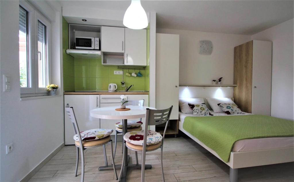 Habitación pequeña con cama, mesa y sillas en Apartments Adria en Baška Voda