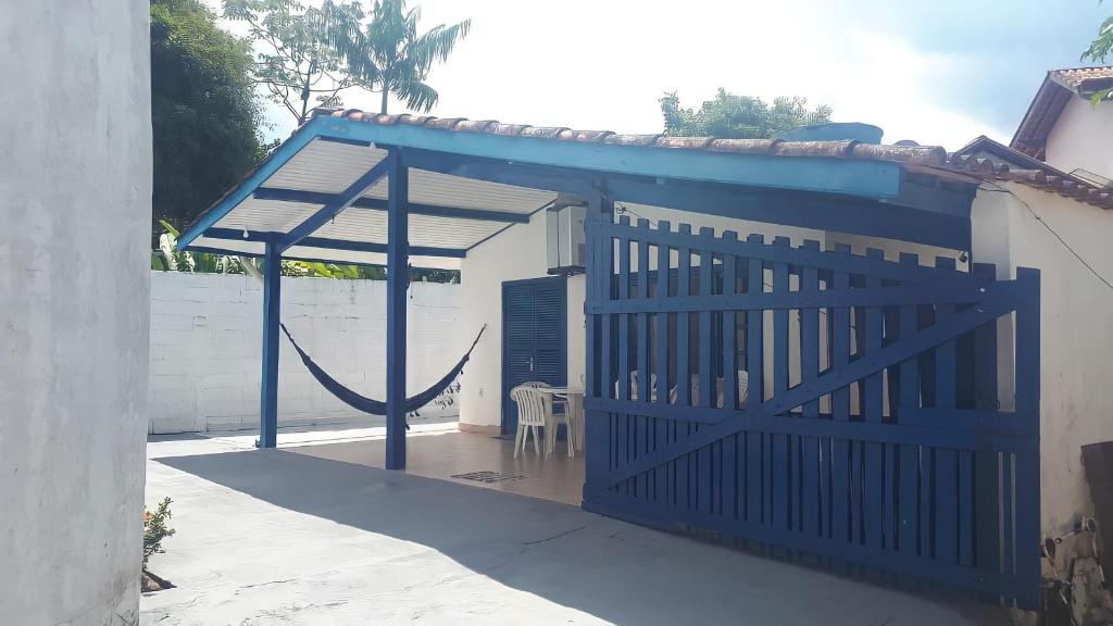 a blue gate to a house with a wooden door at Casa na Praia do Lazaro in Ubatuba