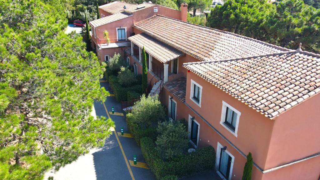 une vue sur une maison avec des arbres devant elle dans l'établissement Hotel du Mas, à Vinassan