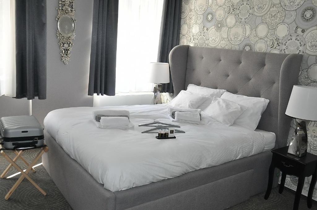 Váralja Home في بودابست: غرفة نوم بسرير كبير مع شراشف بيضاء و اللوح الأمامي كبير
