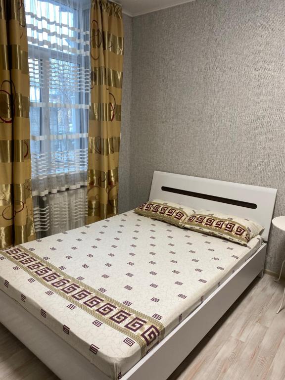 a bed in a bedroom next to a window at Apartment room-біля вокзалу-недалеко від центру in Lviv