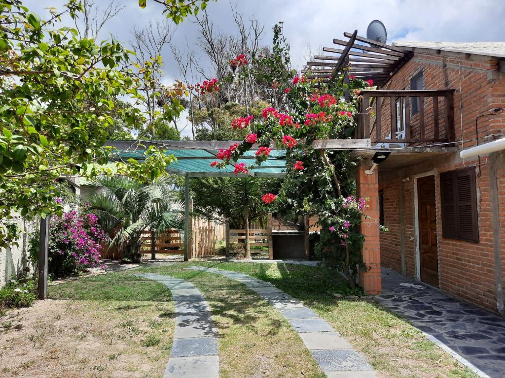 un jardín con rosas colgando de un edificio de ladrillo en Serena, en Barra del Chuy