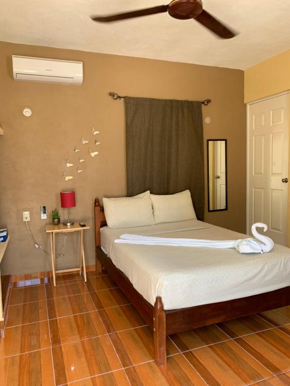 Un dormitorio con una cama y un ventilador de techo. en Estudios Rehilete, en Isla Holbox