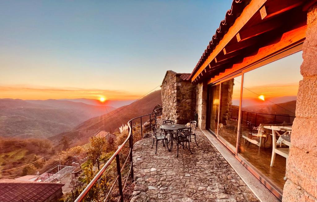 a balcony of a house with a table and chairs at Casa do Ramiscal - Eido do Pomar in Sistelo