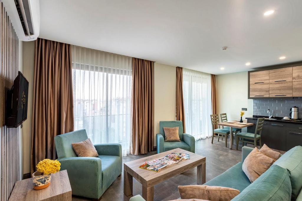 uma sala de estar com um sofá, cadeiras e uma mesa em RODINN Hotel em Antalya