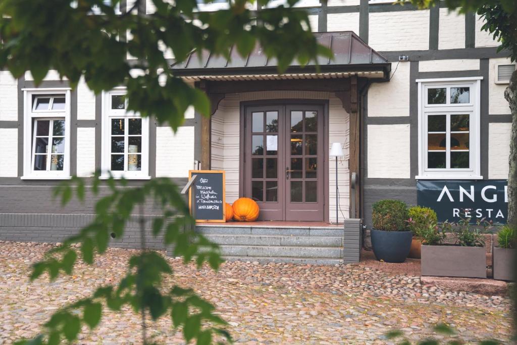 a pumpkin sitting on the front porch of a restaurant at Landart Hotel in Sittensen