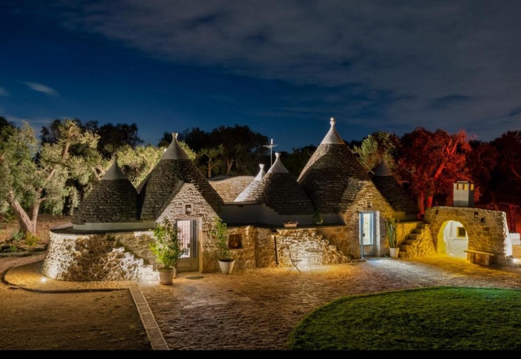 una gran casa de piedra con un patio por la noche en Trullo DONNA LUCIA, en Latiano