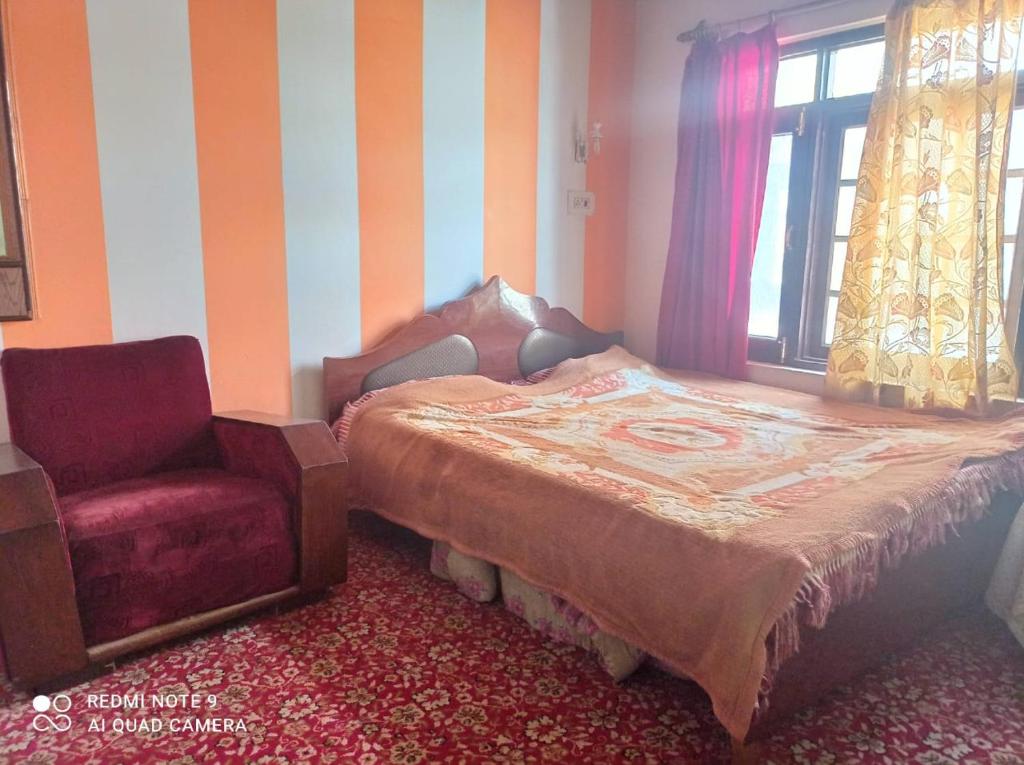 a bedroom with a bed and a chair and a window at Al Amin Homestay in Srinagar