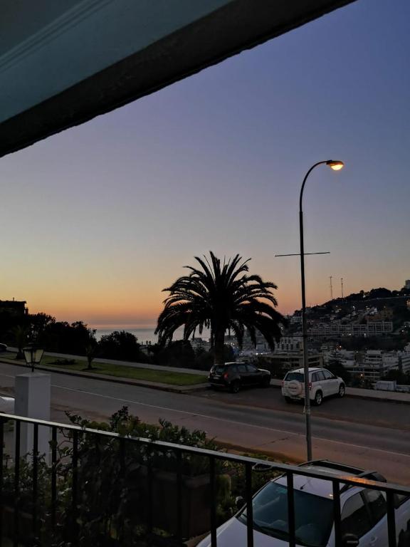 a parking lot with a palm tree and a street light at Departamento La Palmera in Viña del Mar