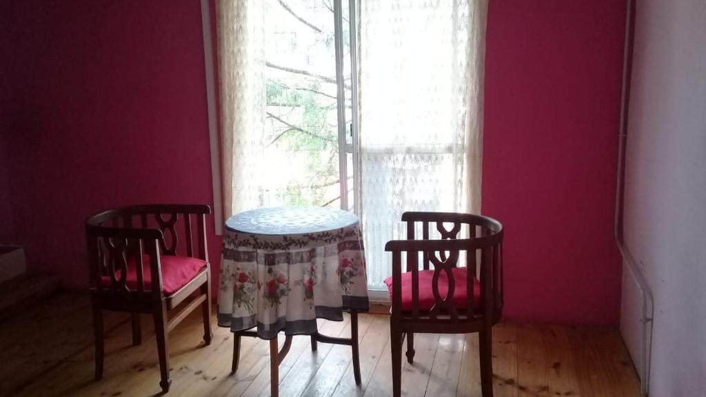 mesa y sillas en una habitación con ventana en 9 de julio en Villa Mercedes