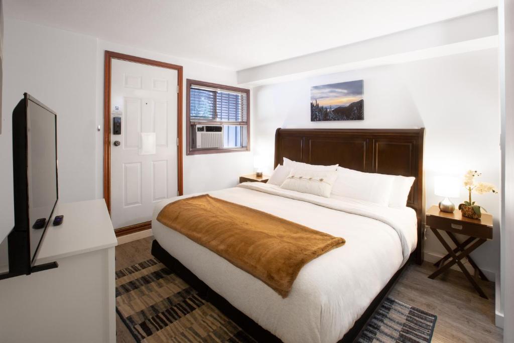um quarto com uma grande cama branca e uma cabeceira em madeira em Attractive Townhouse in Whistler Village with Hot Tub em Whistler