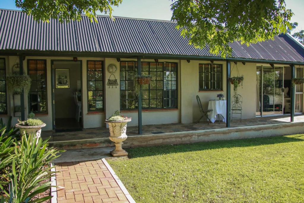 a building with a porch with windows and a yard at Idavold Gate House in Howick