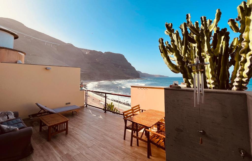 a balcony with a view of the ocean and a cactus at OvertheOcean Big terrace and XL Bed in Cabo Verde