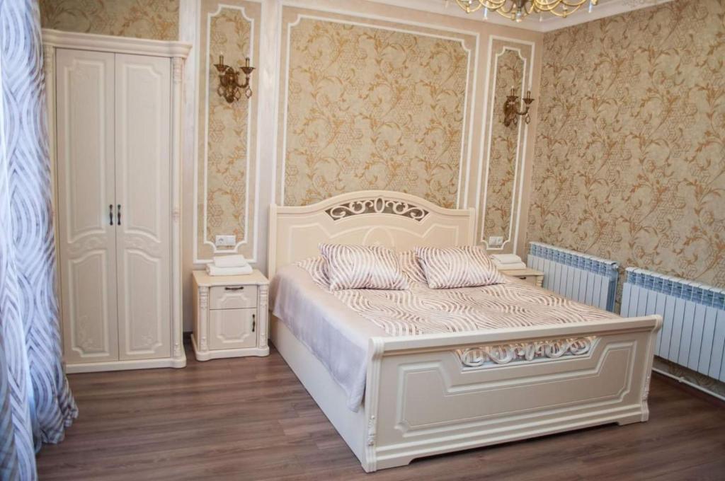 ein Schlafzimmer mit einem weißen Bett und einem Kronleuchter in der Unterkunft Ahana Hotel in Martuni in Martuni
