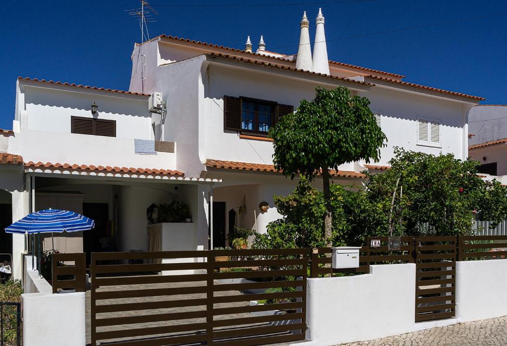 una casa blanca con una valla de madera delante de ella en Familia Brito en Porches