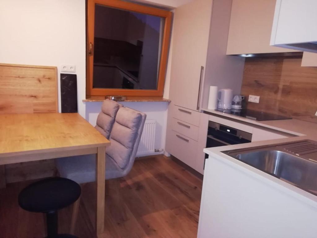 a kitchen with a sink and a table and a chair at Haus Meißnitzer in Taxenbach