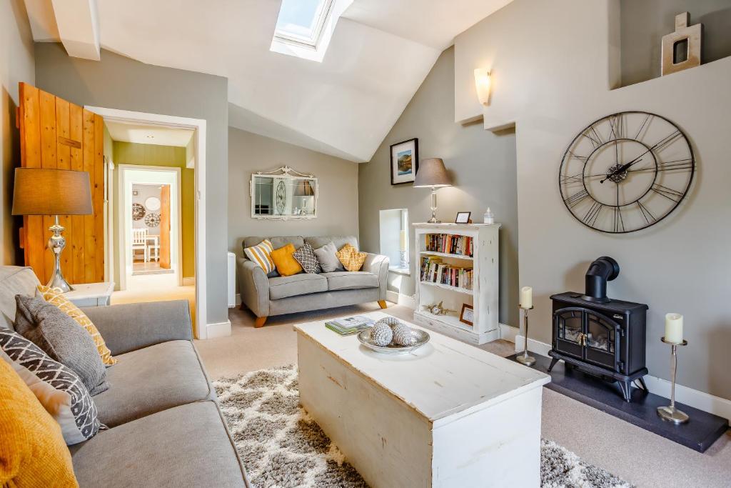 a living room with a couch and a stove at Broadrock Accommodation - Clock Cottage in Chepstow