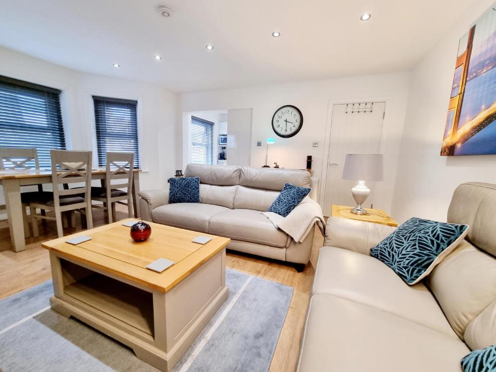 a living room with white furniture and a table at Bournemouth Luxury Apartment in Bournemouth