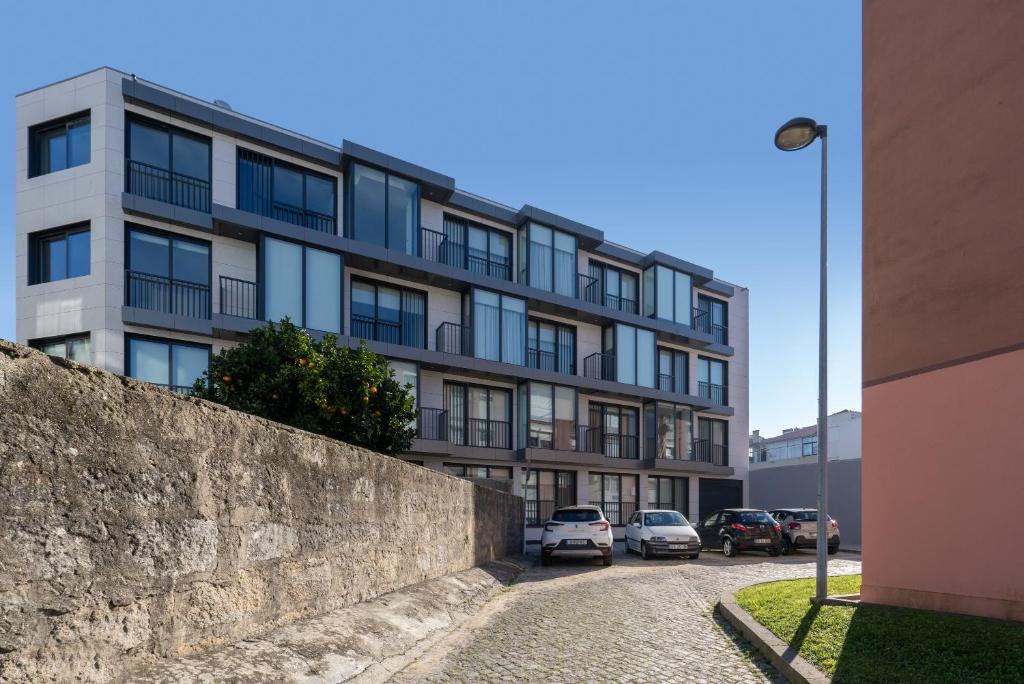 un edificio con coches estacionados frente a él en Habitatio - Bom Sucesso, en Oporto