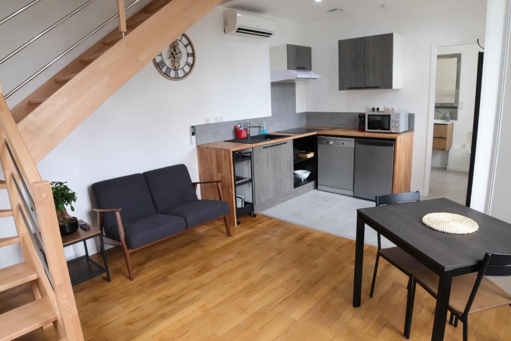 cocina y sala de estar con mesa y sofá en Le temps d'une pause', 