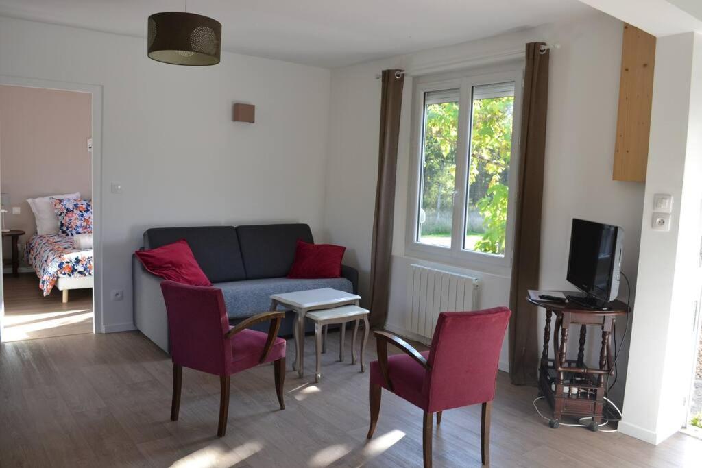 ein Wohnzimmer mit einem Sofa und roten Stühlen in der Unterkunft Sologne - Maison indépendante au cœur des châteaux in Cheverny