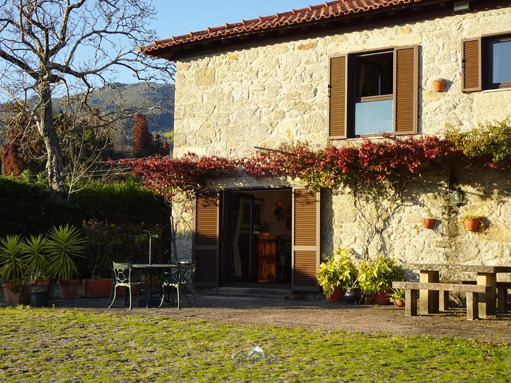 una casa in pietra con un tavolo di fronte di LIMA COTTAGES - Casa do Cercado a Arcos de Valdevez