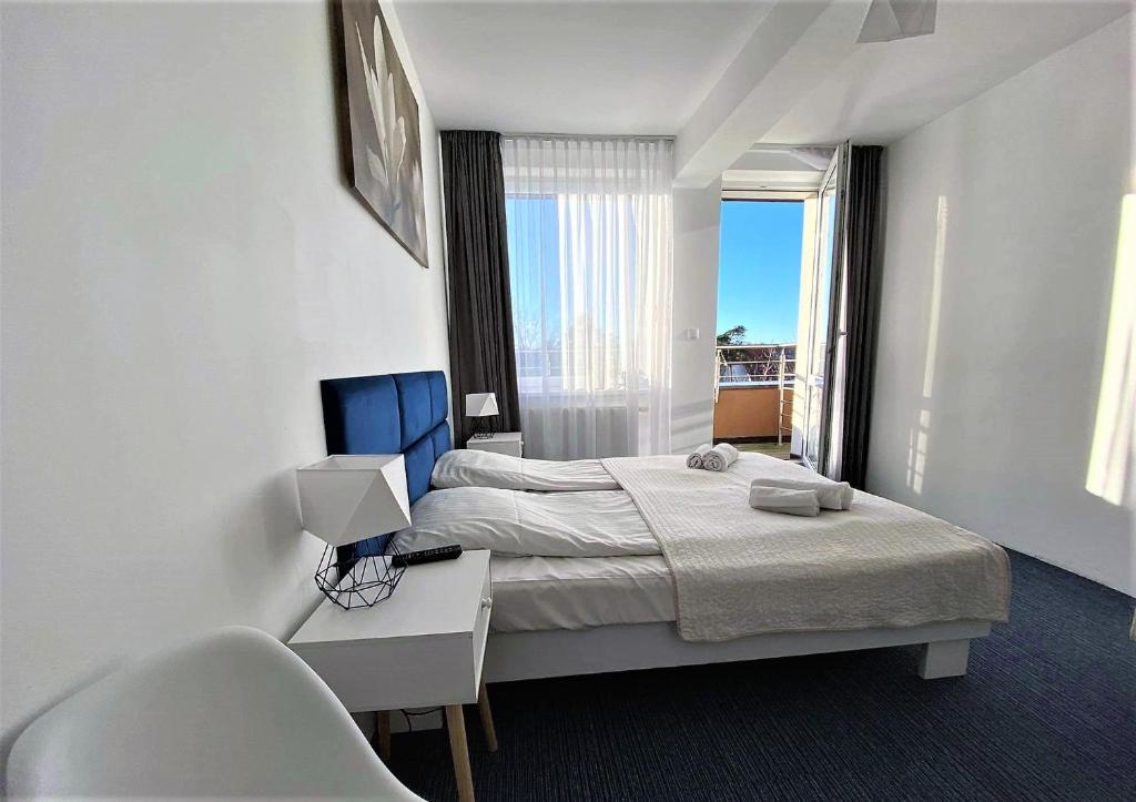 Habitación de hotel con 2 camas, mesa y silla en Apartamenty Planeta Mielno, en Mielno